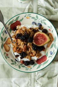apple and cinnamon granola in a bowl with fresh fruit
